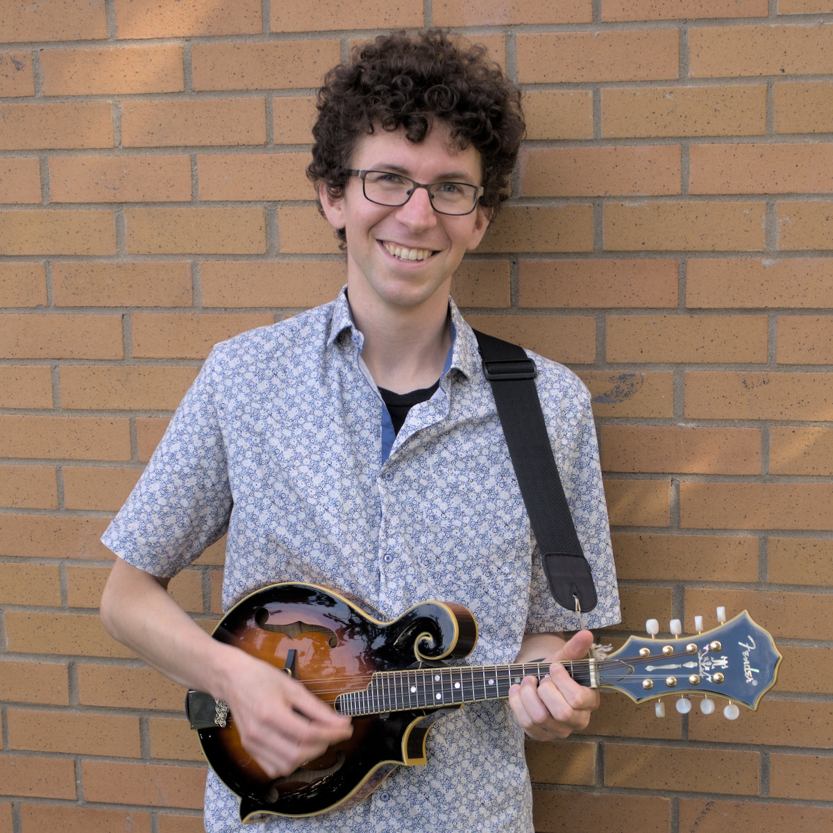 Photo of Jacob holding a mandolin